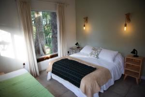 1 dormitorio con 2 camas y ventana grande en Estancia La Titina, Posada y Reserva Natural en Concepción del Uruguay