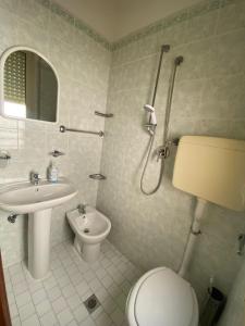 uma casa de banho com um chuveiro, um WC e um lavatório. em Albergo Acapulco em Bellaria-Igea Marina