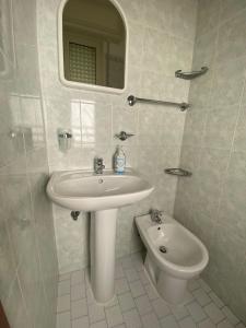 Baño blanco con lavabo y aseo en Albergo Acapulco, en Bellaria-Igea Marina