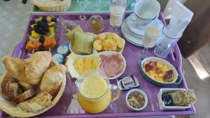 purpurowy stół z tacą ze śniadaniem i napojami w obiekcie POUSADA NICO ON THE HILL w mieście Monte Verde