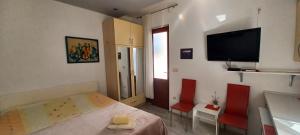 a bedroom with a bed and two red chairs at Apartman studio Babilo 1 in Omiš