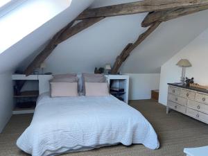 a bedroom with a white bed and a dresser at maison 8 pers avec piscine en pleine nature in Ambenay