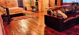 Hocking Hills Rusty Lofts في لوغان: غرفة معيشة مع أريكة وأرضية خشبية