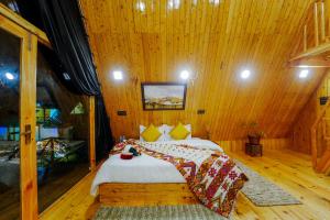 a bedroom with two beds in a wooden room at Himalayan Manor A-Frame Cabin in Sainj