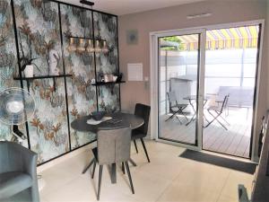 a dining room with a table and chairs and a patio at MOR-HA-MARCH Studio in Sarzeau
