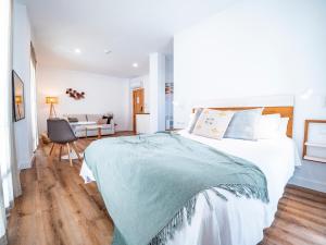 a bedroom with a large bed and a desk at Posada El Convento Mercedario by Ĥ in Ayamonte