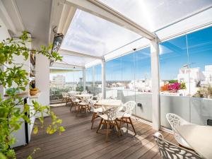 een balkon met tafels, stoelen en ramen bij Posada El Convento Mercedario by Ĥ in Ayamonte