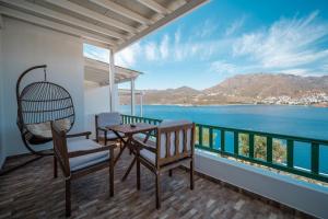 a balcony with a table and chairs and the ocean at Astrio Suites in Livadi