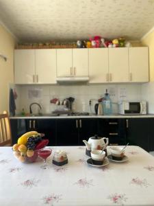 a kitchen with a table with a bowl of fruit on it at The Nest Hostel in Karakol