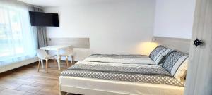 ジビジノにあるNawigator Apartamenty - Dźwirzynoのベッドルーム1室(ベッド1台、テーブル、窓付)