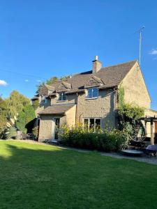 una grande casa in mattoni con un prato di fronte di Totally Private, idyllic House with hot tub in an acre of private gardens a South Cerney Altre 85 foto