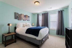 sypialnia z łóżkiem z niebieskimi ścianami i oknem w obiekcie Spacious Family Friendly Townhome in Central Park w mieście Denver