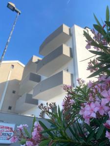 a white building with purple flowers in front of it at ViesteRooms in Vieste