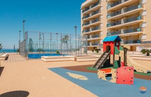 a playground with a slide in front of a building at Dos Mares Norte 414B in San Blas