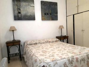 1 dormitorio con 1 cama y 2 mesas con lámparas en Departamentos Virgen del Cerro en Salta