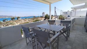 a table and chairs on a balcony with a view of the ocean at Marianos Apartments in Antiparos