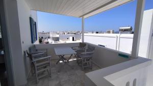 a balcony with a table and chairs on a roof at Marianos Apartments in Antiparos +112 photos
