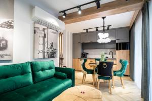 a living room with a green couch and a table at Apartament Niebiańska Polana by Apart Concept Podhale in Kościelisko