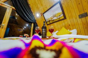 a table with two glasses of wine and a bottle at Himalayan Manor A-Frame Cabin in Sainj