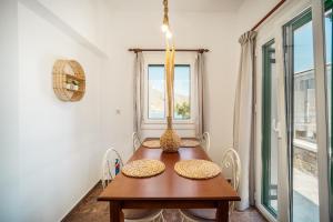 a dining room with a wooden table and a window at Astrio Suites in Livadi