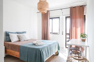ein kleines Schlafzimmer mit einem Bett mit einem Tisch und Stühlen in der Unterkunft Peniche Surf Apartment in Peniche