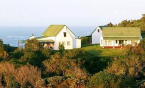 a house sitting on top of a hill next to the ocean at Bishops Cove in Eersterivierstrand