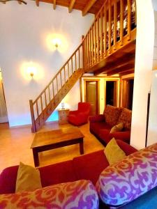uma sala de estar com sofás vermelhos e uma escadaria em Casas Rurales Venta Ticiano em El Morrion