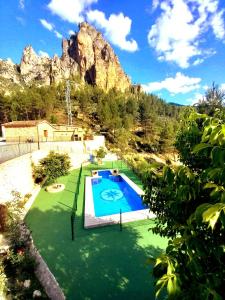 een zwembad in een tuin met een berg op de achtergrond bij Casas Rurales Venta Ticiano in El Morrion