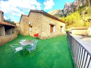 d'une terrasse avec de la pelouse verte, une table et des chaises. dans l'établissement Casas Rurales Venta Ticiano, à El Morrion