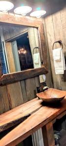 a wooden counter with a sink and a mirror at Hocking Hills Rusty Lofts in Logan