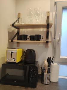 a kitchen with a microwave and wine glasses on shelves at Bonito estudio con garaje in Bilbao