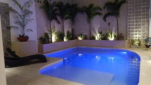 a swimming pool in a room with plants at Hotel Yaxactun in Progreso