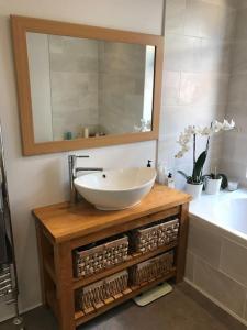 a bathroom with a sink and a mirror and a tub at Falcon Cottage - 6 Guests, Sea Views in East Cowes