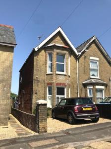 a car parked in front of a brick house at Falcon Cottage - 6 Guests, Sea Views in East Cowes