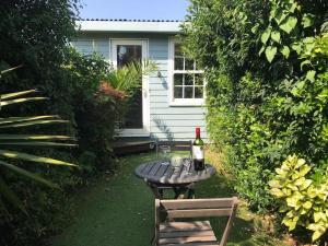 a bottle of wine sitting on a table in front of a house at Falcon Cottage - 6 Guests, Sea Views in East Cowes