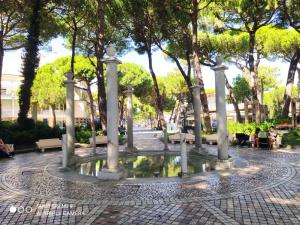 una fuente en medio de un parque con árboles en Residence Rialto en Milano Marittima