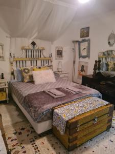 een slaapkamer met een groot bed en een piano bij Casa Esti in Olhão