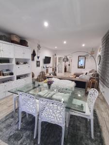 a living room with a glass table and chairs at Casa Esti in Olhão