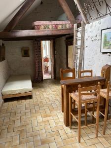 La Maison du meunier في رومورانتا: غرفة مع طاولة وكراسي وسرير بطابقين