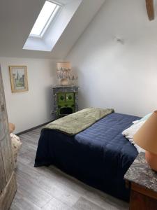 羅莫朗坦的住宿－La Maison du meunier，一间卧室配有一张床和一个绿色的炉灶