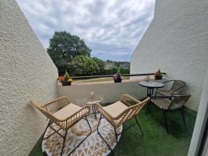 d'un balcon avec deux chaises, une table et une table. dans l'établissement GUIDEL-PLAGES Studio Lumineux Balcon Vue Mer & Piscine, à Guidel