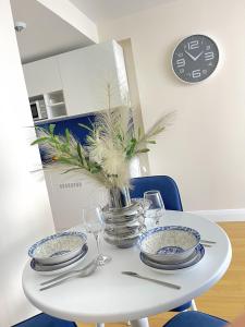 a white table with plates and a vase with a plant at Apartments Black Sea Resort in Batumi