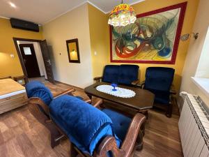 uma sala de estar com cadeiras, uma mesa e um quadro em Familia 2 em Rabka