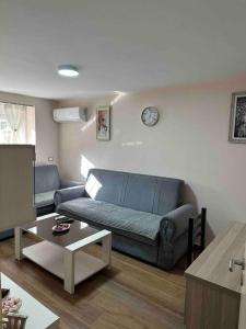 uma sala de estar com um sofá e uma mesa em Lovely one bedroom flat in Durres em Durrës