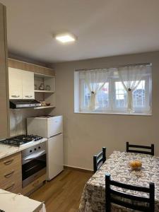 uma cozinha com uma mesa, um fogão e uma janela em Lovely one bedroom flat in Durres em Durrës