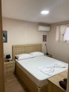 um quarto com uma grande cama branca num quarto em Lovely one bedroom flat in Durres em Durrës
