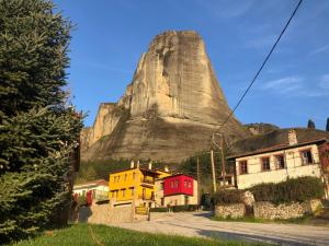 a mountain with houses in front of it at Archontiko Mesohori Meteora in Kalabaka