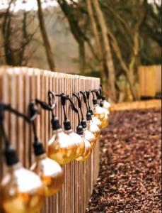 a row of wine bottles attached to a wooden fence at Cliff Stud Retreat - Luxury lodges and cosy cottages in Helmsley