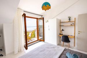 a bedroom with a bed and a desk and a window at Lux Gradac in Gradac