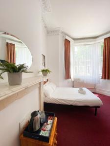 a room with two beds and a mirror at Orlando hotel in London